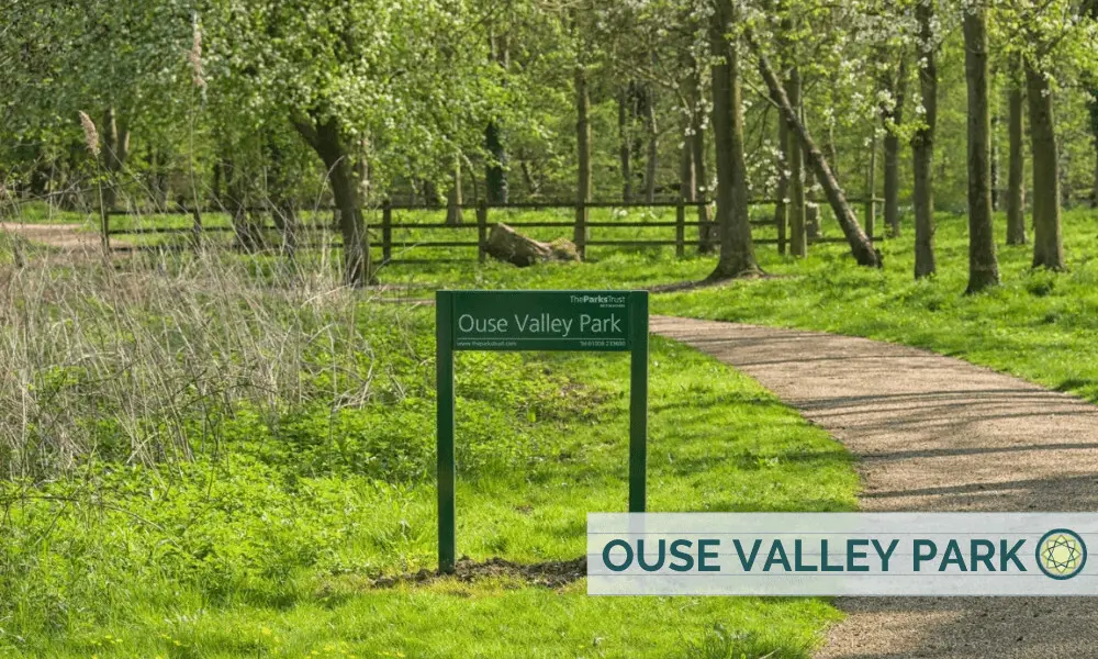 Path winding between grass and trees in Ouse Valley park in spring